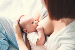 Try different breastfeeding positions to make it more comfortable to nurse while pregnant